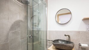 A bathroom with a glass-enclosed shower, a round mirror, and a vessel sink on a wooden vanity. - 3 Bed in Belford (oc-cn065) (Easington)