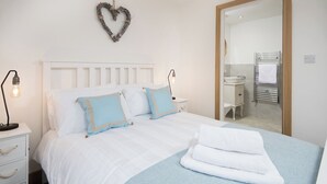 A bedroom with a bed, bedside table, lamp, and a mirror reflecting a bathroom. - 3 Bed in Belford (oc-cn065) (Easington)