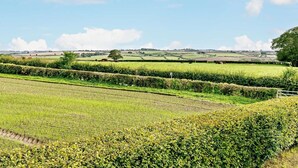 A rural landscape with fields, hedgerows, and distant hills under a clear sky. - 3 Bed in Market Rasen (oc-93253) (Ranby)