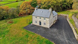 A stone house with a paved driveway and a grassy yard. - 3 Bed in Brecon (oc-93680) (Llandefalle)