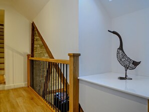 A staircase with wooden railings and a white wall with a metal sculpture of a bird. - 3 Bed in Brecon (oc-93680) (Llandefalle)