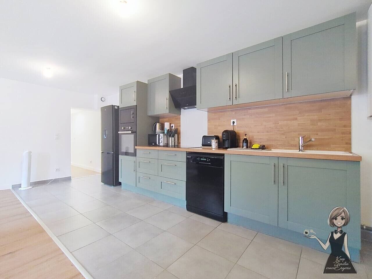 A modern kitchen with light blue cabinets, a wooden countertop, a black dishwasher, and a black refrigerator.