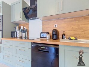 Eine moderne Küche mit Geschirrspüler, Mikrowelle, Toaster und Kaffeemaschine auf der Arbeitsfläche.