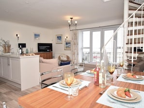 A modern kitchen with a dining area, a TV, and a staircase. - 3 Bed in Seahouses (oc-cn097) (Seahouses)