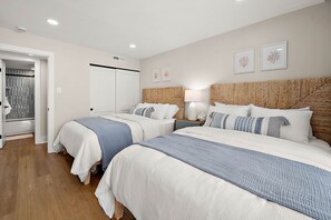 A hotel room with two beds, a wardrobe, a bathroom, and a view of the sea. - Ocean Side Condo | Steps to the Beach (Ocean City)