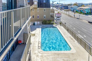 A rooftop pool with a view of the street and buildings. - Ocean Side Condo | Steps to the Beach (Ocean City)