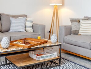 Una sala moderna con un sofá, una mesa de centro y una lámpara de pie.