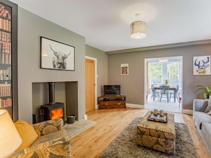 A living room with a fireplace, a television, and a dining area with a table and chairs. - 2 Bed in Hexham (oc-79240) (Kielder)