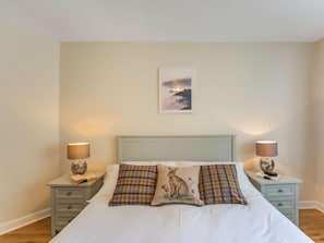 A bedroom with a bed, two bedside tables, and a wall-mounted picture. - 2 Bed in Hexham (oc-79240) (Kielder)
