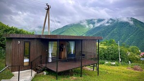 Una petita cabana de fusta amb un balcó, una sola porta i una escala que condueix a l'entrada.
