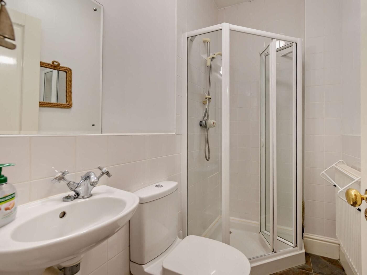 Een badkamer met een wastafel, toilet en douchecabine.
