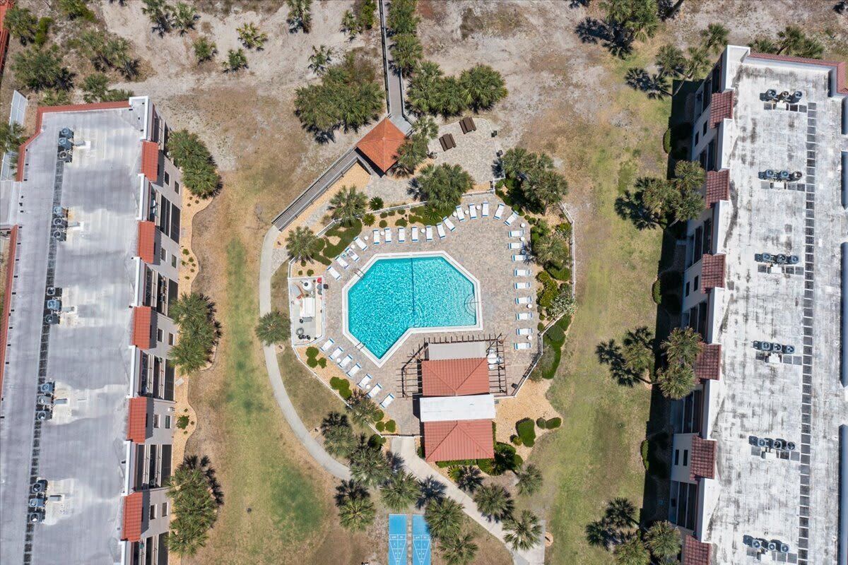 Vista aèria d'un hotel amb una piscina central, diverses zones de relaxació i un aparcament.