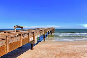 A wooden pier extending into the ocean with a clear sky above. - New! St. Augustine Resort Condo With Free Tickets (St. Augustine)