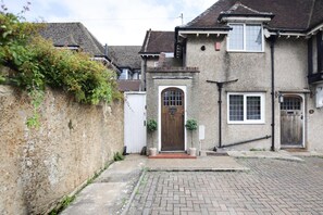 A two-story house with a front door, a small porch, and a brick driveway. - 2 Bed in Eastbourne (oc-83735) (Eastbourne)
