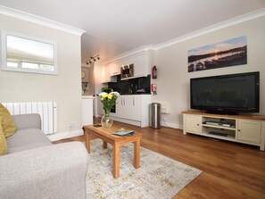 A modern living room with a sofa, coffee table, and a flat-screen TV. - 1 Bed in Keswick (oc-sz468) (Keswick)