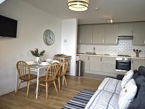 A modern kitchen with grey cabinets, a built-in oven, and a stainless steel sink. - 2 Bed in Ilfracombe (oc-87979) (Ilfracombe)
