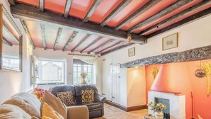 Un salon chaleureux avec une cheminée, un canapé et une fenêtre.