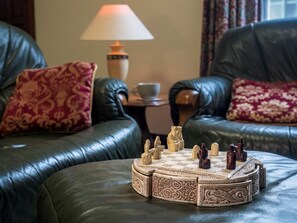 A living room with a chessboard, leather sofas, patterned cushions, a lamp, and a cup on a side table. - 3 Bed in Cromer (oc-88327) (Northrepps)