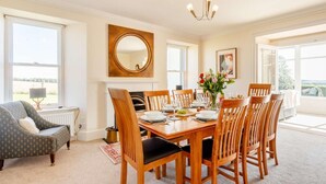 A dining room with a wooden table set for six, surrounded by six wooden chairs. - 4 Bed in Brechin (oc-89698) (Brechin)