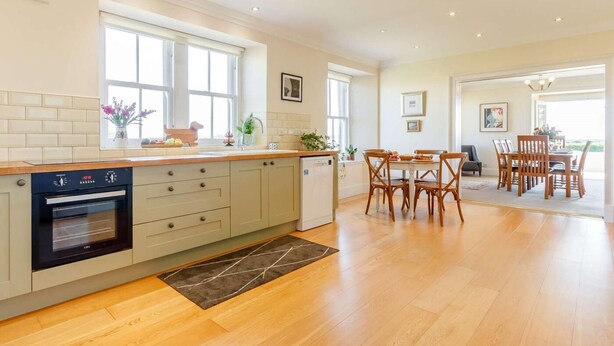 A modern kitchen with a built-in oven, a dining area with wooden chairs, and a view of the outdoors. - 4 Bed in Brechin (oc-89698) (Brechin)