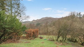 A rural landscape with a grassy field, trees, and hills in the background. - 3 Bed in Broughton-in-furness (oc-91862) (Broughton Mills)