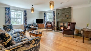 A living room with a sofa, armchairs, a fireplace, and a television. - 3 Bed in Broughton-in-furness (oc-91862) (Broughton Mills)
