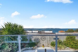 A rooftop terrace with a view of the sea, a wooden fence, and various plants. - 3 Bed in Brixham (oc-93564) (Brixham)