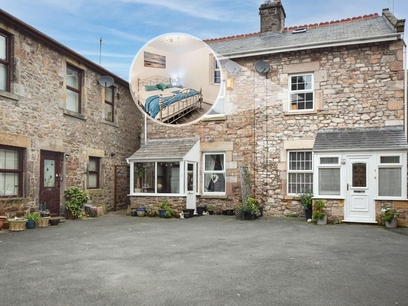 A stone building with a courtyard, a bed with a view, and a satellite dish.