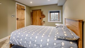 Une chambre à coucher avec un lit, une fenêtre, une porte et un thermostat.