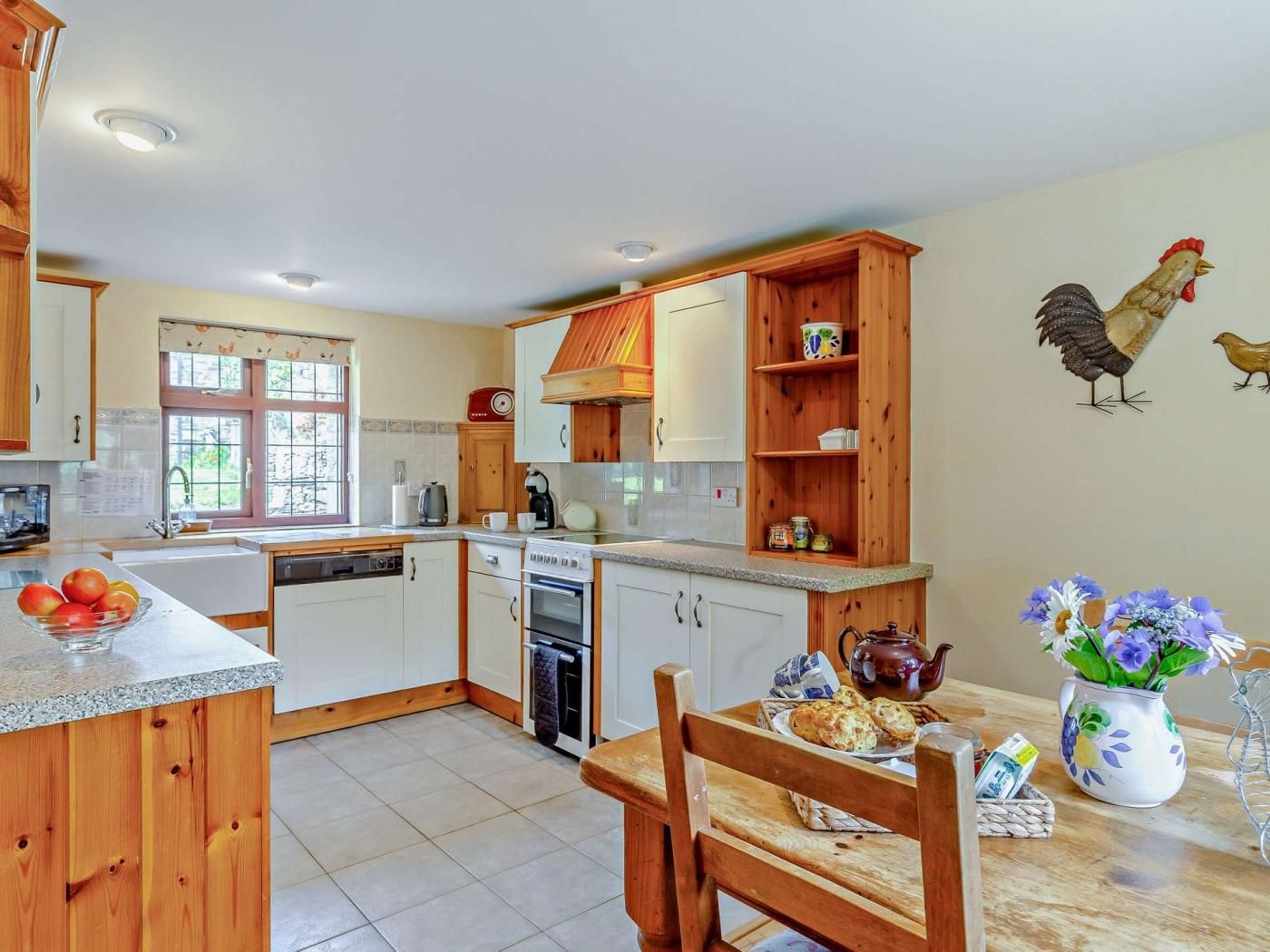 A kitchen with wooden cabinets, a built-in oven, and a dining area with a table set for two.
