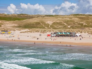 A beach with a building and tents, a sandy shore, and waves. - 1 Bed in Perranporth (oc-colma) (Perranporth)