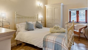 A bedroom with a bed, bedside lamps, a wardrobe, a window, and a chair. - 2 Bed in Callington (oc-tyler) (South Hill)