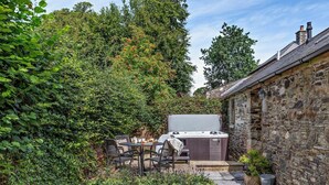 A stone building with a hot tub, outdoor seating, and a garden area. - 2 Bed in Callington (oc-tyler) (South Hill)
