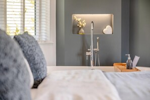 A modern bathroom with a shower, a vanity with a mirror, and a bedside table with a bottle and a tissue box. - 2 Bed in Weymouth (oc-75200) (Weymouth)