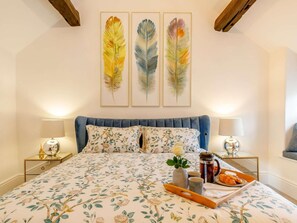 A bedroom with a bed, pillows, a bedside table, a lamp, and a tray with food. - 1 Bed in Hope Valley (oc-89720) (Hope)