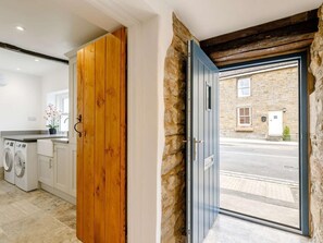 A laundry room with a wooden door and a stone wall. - 1 Bed in Hope Valley (oc-89720) (Hope)