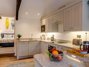 A modern kitchen with a granite countertop, a fruit basket, and a vintage radio. - 1 Bed in Hope Valley (oc-89720) (Hope)