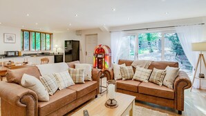 A living room with two sofas, a coffee table, and a jukebox. - 1 Bed in Harrogate (oc-93258) (Thornthwaite)