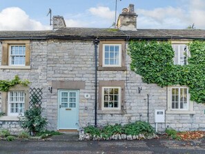 A stone building with a light blue door, windows, and a chimney. - 2 Bed in Ashford In The Water (oc-85823) (Ashford in the Water)