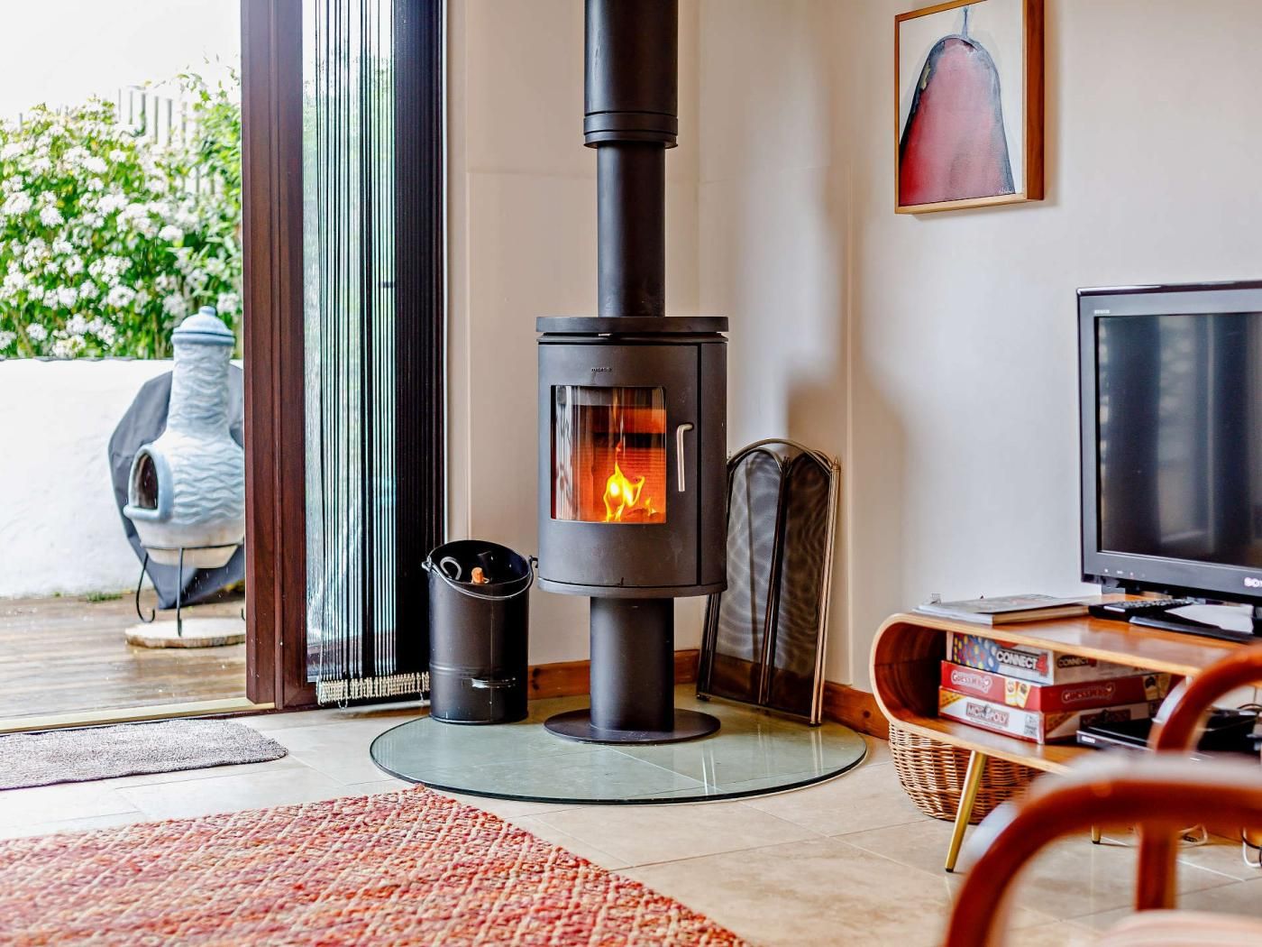 A modern living room with a wood-burning stove, a television, and a fireplace.