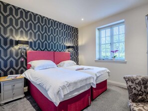 A bedroom with a bed, bedside tables, a window with blinds, and a patterned wall. - 2 Bed in Norwich (oc-77807) (Ashmanhaugh)