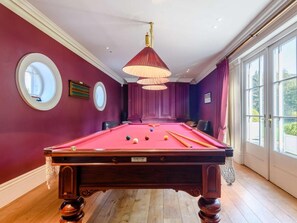 A pool table in a room with large windows, a round mirror, and a chandelier. - 2 Bed in Norwich (oc-77807) (Ashmanhaugh)