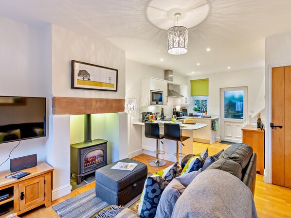 Een moderne woonkamer met een open haard, een televisie en een bank.