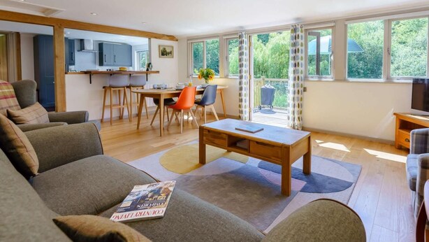 A modern living room with a sofa, a coffee table, and a dining area with chairs and a table. - 2 Bed in Uckfield (oc-80504) (Framfield)
