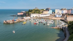 A coastal town with a harbor, colorful buildings, and a prominent lighthouse. - 3 Bed in Tenby (oc-fb225) (Tenby)