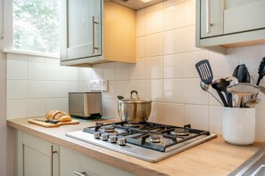Eine Küche mit einem Gaskochfeld, einem Toaster und einem Topf auf der Arbeitsfläche.