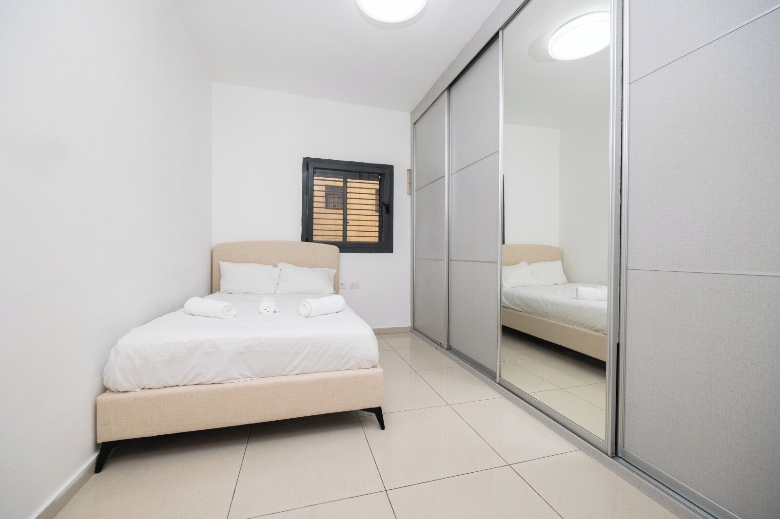 Une chambre à coucher avec un lit, une fenêtre et une porte coulissante.