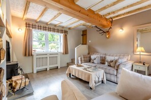 A cozy living room with a plaid sofa, a fireplace, and a deer antler decoration. - 1 Bed in Callander (oc-pe173) (Strathyre)