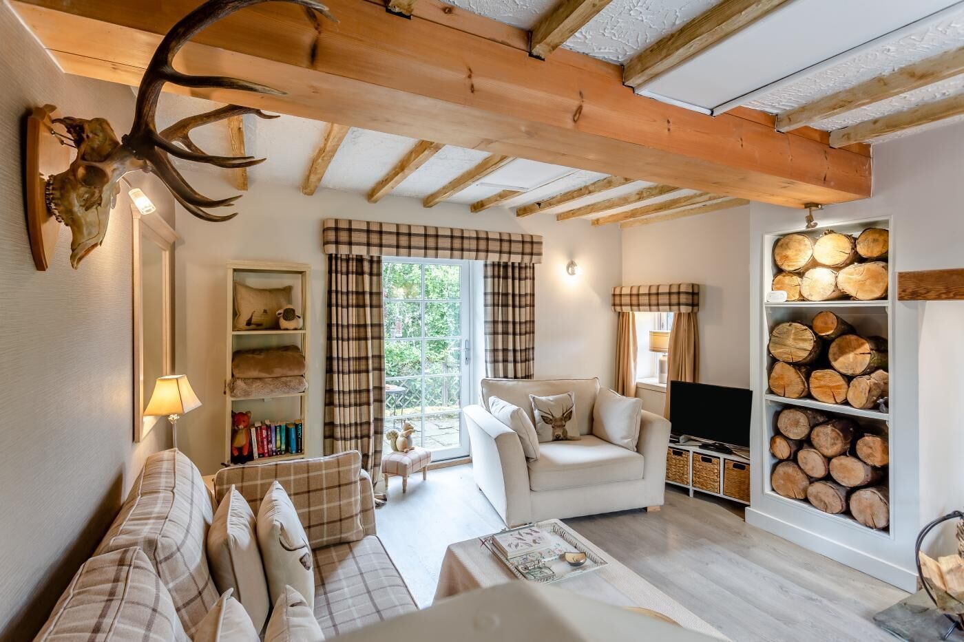A cozy living room with a sofa, a television, and a fireplace.