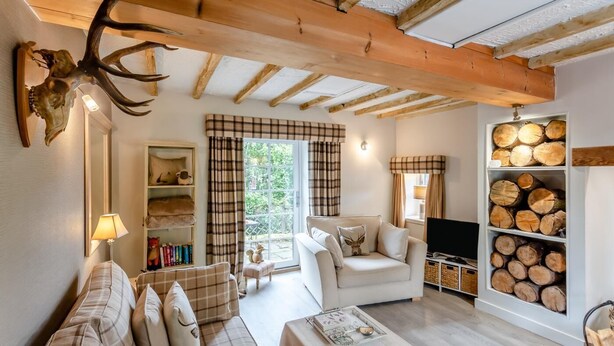 Ein gemütliches Wohnzimmer mit einer Couch, einem Fernseher und einem Kamin.